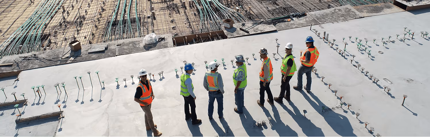 Construction crew in hi-vis vests on an active rooftop jobsite — the preconstruction teams Boon AI builds for